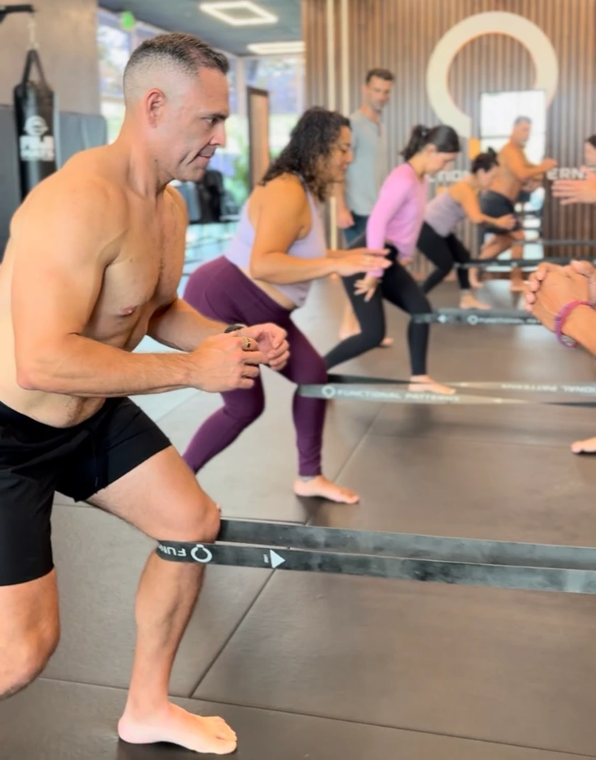A semi-private group performing Functional Patterns work with resistance bands at FP Costa Mesa.