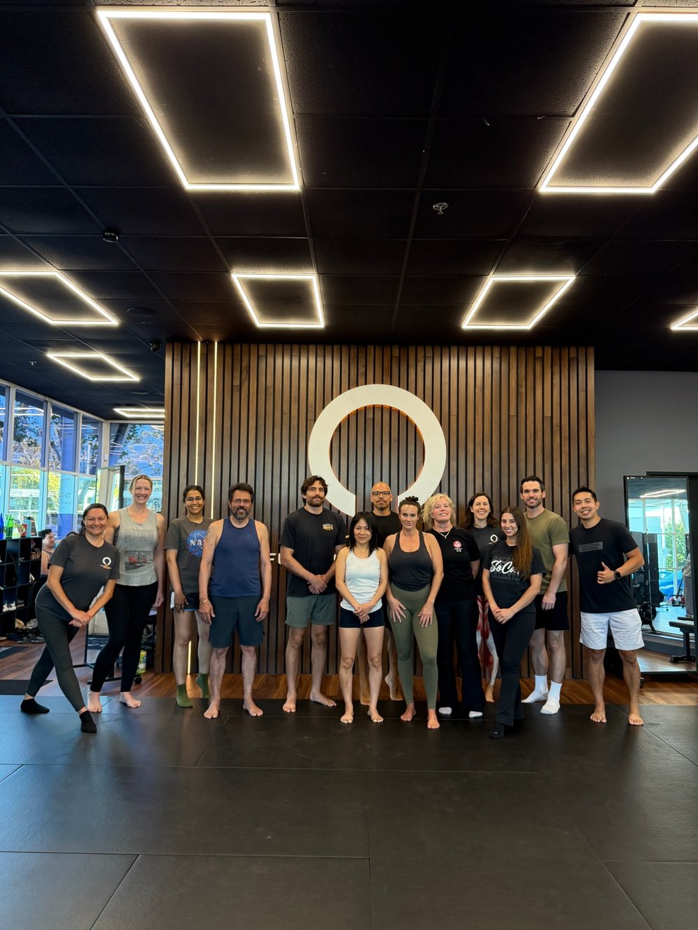A Functional Patterns class group in front of the studio logo wall at FP Costa Mesa